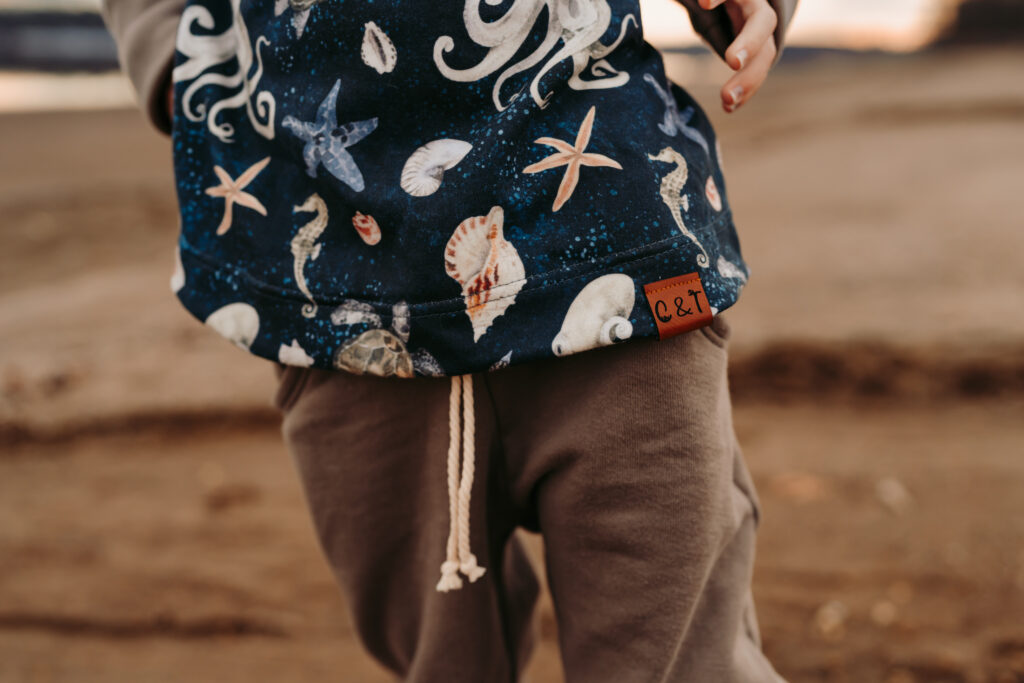 Close up detail shot of a sweater with prints of seashells and seahorses on it